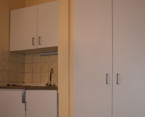 Küchenzeile mit Herd und Spülbecken sowie Kleiderschrank in der Gästewohnung Franz-Körner-Str. 61a