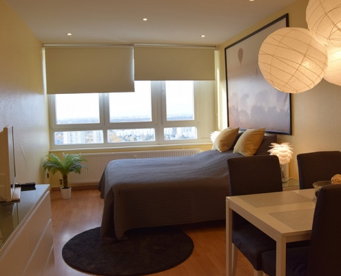 Blick auf den Schlafbereich mit Bett in der zweiten Gästewohnung in der Fritz-Erler-Allee 120